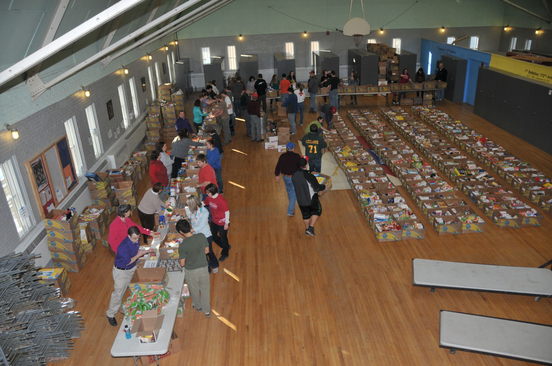 Volunteers fill boxes with food at the National Guard Armory in St. Albans.